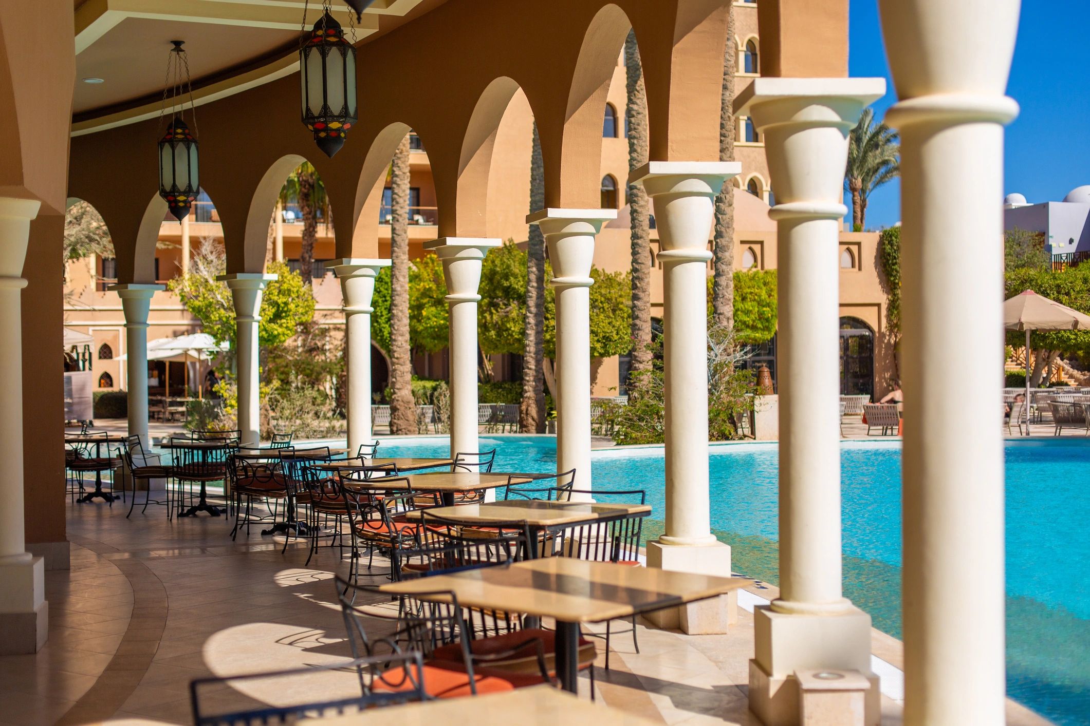 Outdoor hotel dining terrace beside a pool